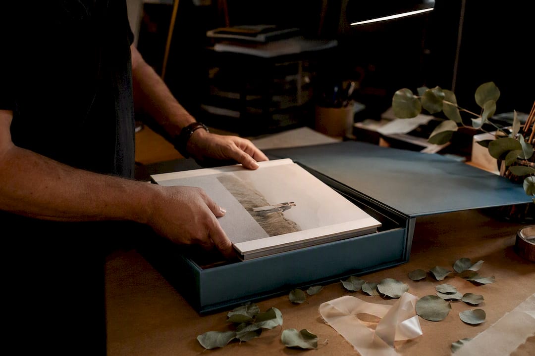Hands packaging wedding album in box