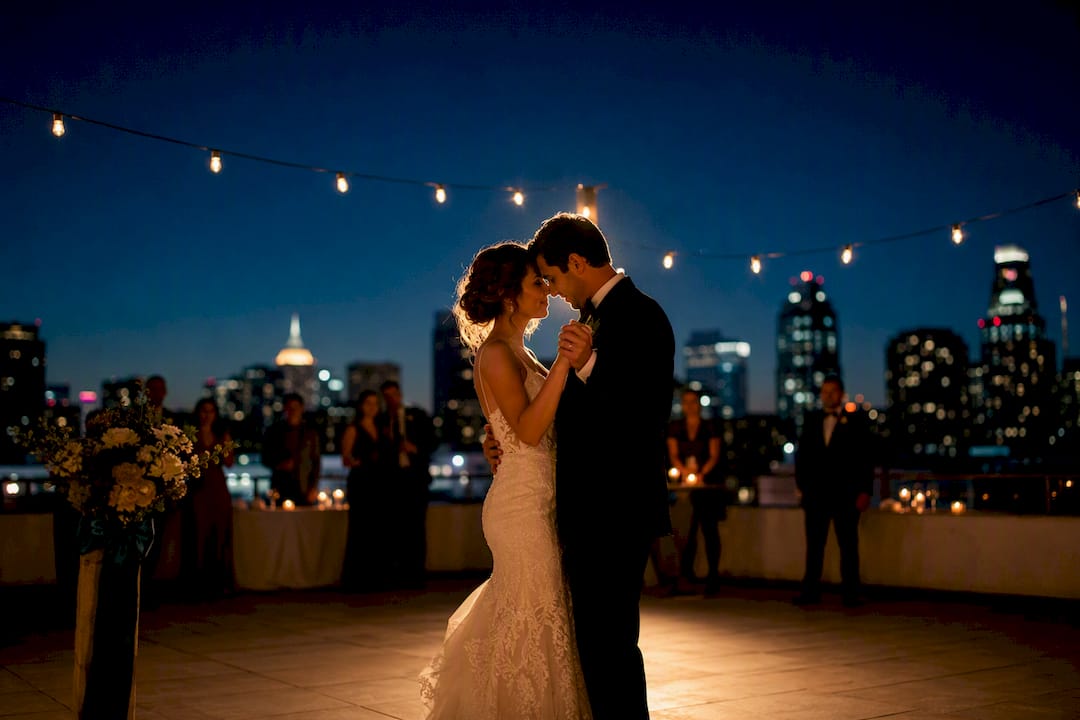 Couple dancing beneath night wedding lights