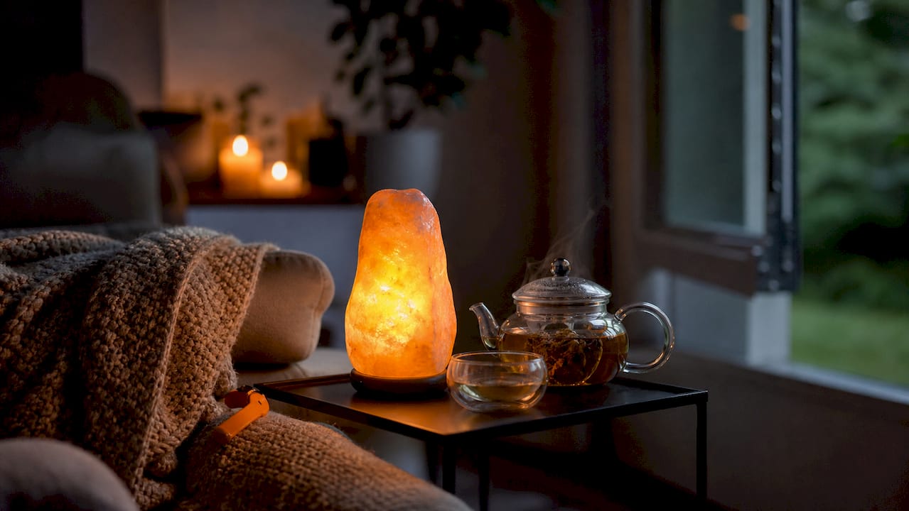 Warm glow from Himalayan salt lamp on bedside table