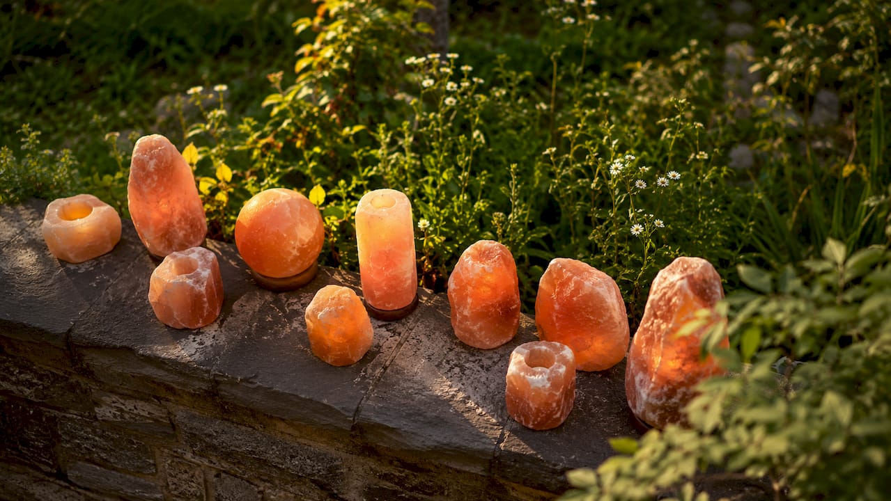 Close-up of natural rough Himalayan salt lamps on rustic shelf