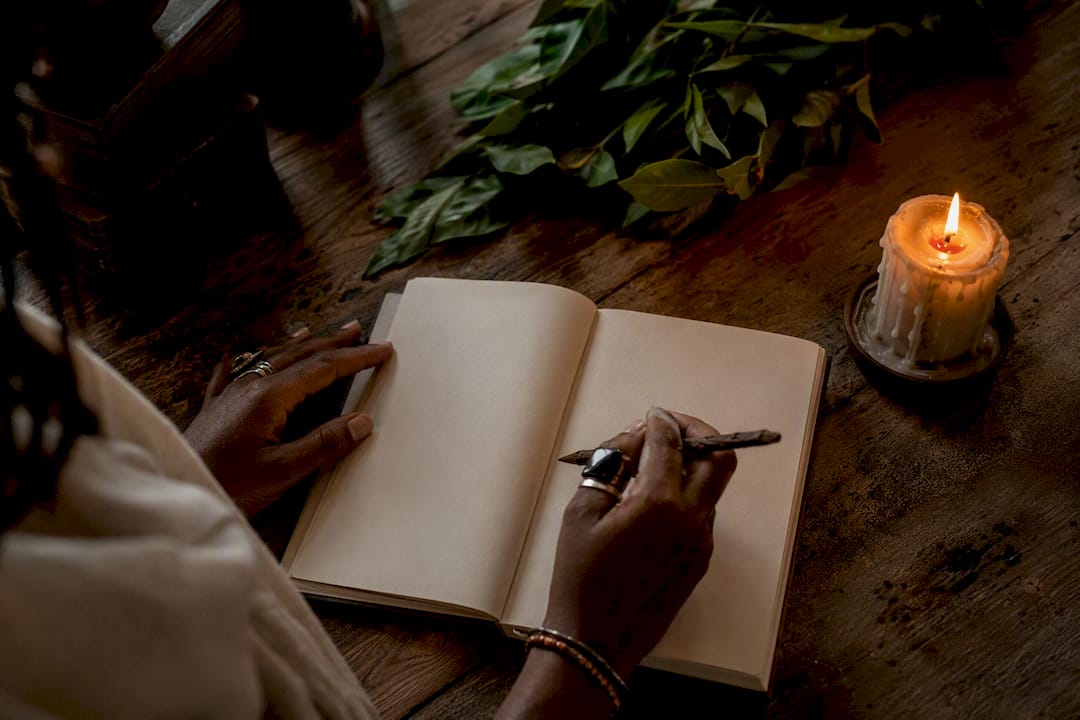Hands writing personal testimonial in journal