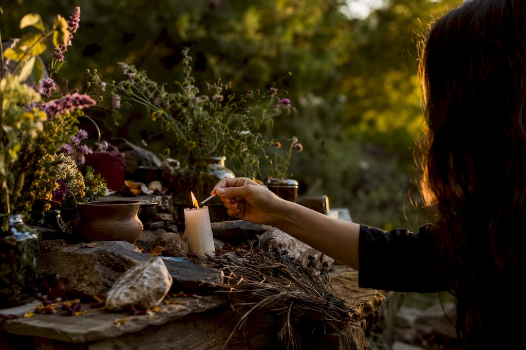Hand lighting a candle for ancestral ritual