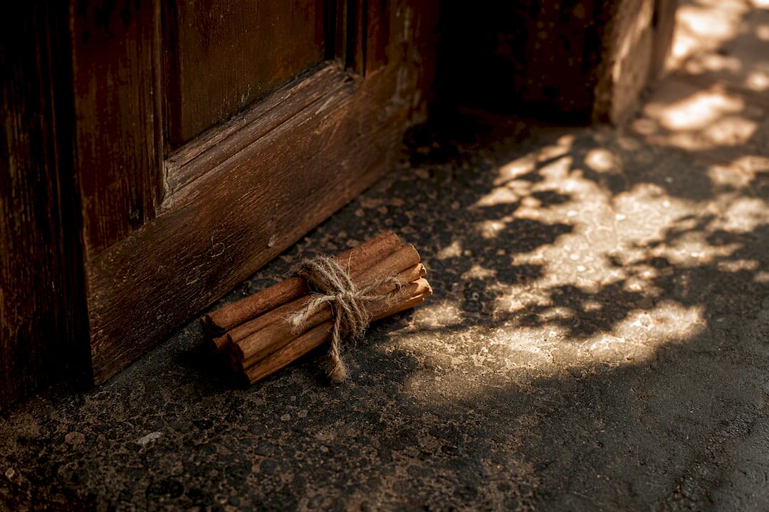 Cinnamon sticks tied with twine on wooden doorway threshold