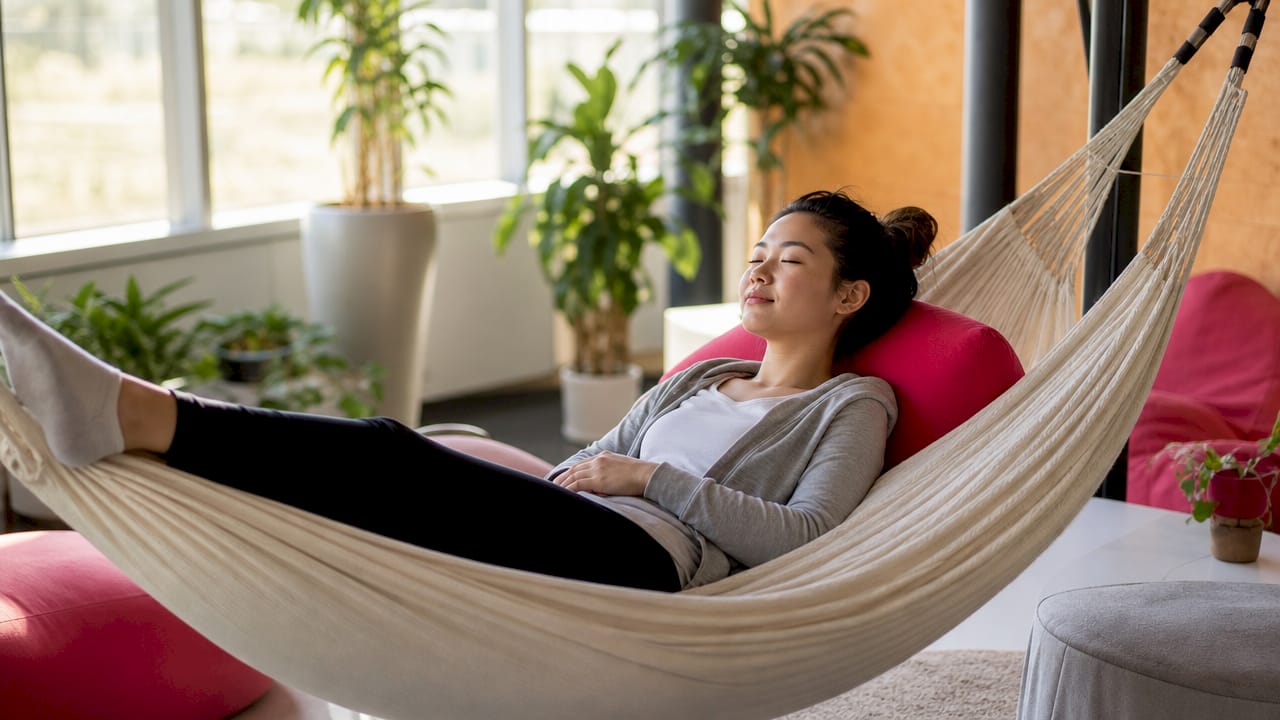 Una donna si prende un momento per meditare durante un ritiro aziendale, immersa in un’atmosfera di relax e concentrazione.