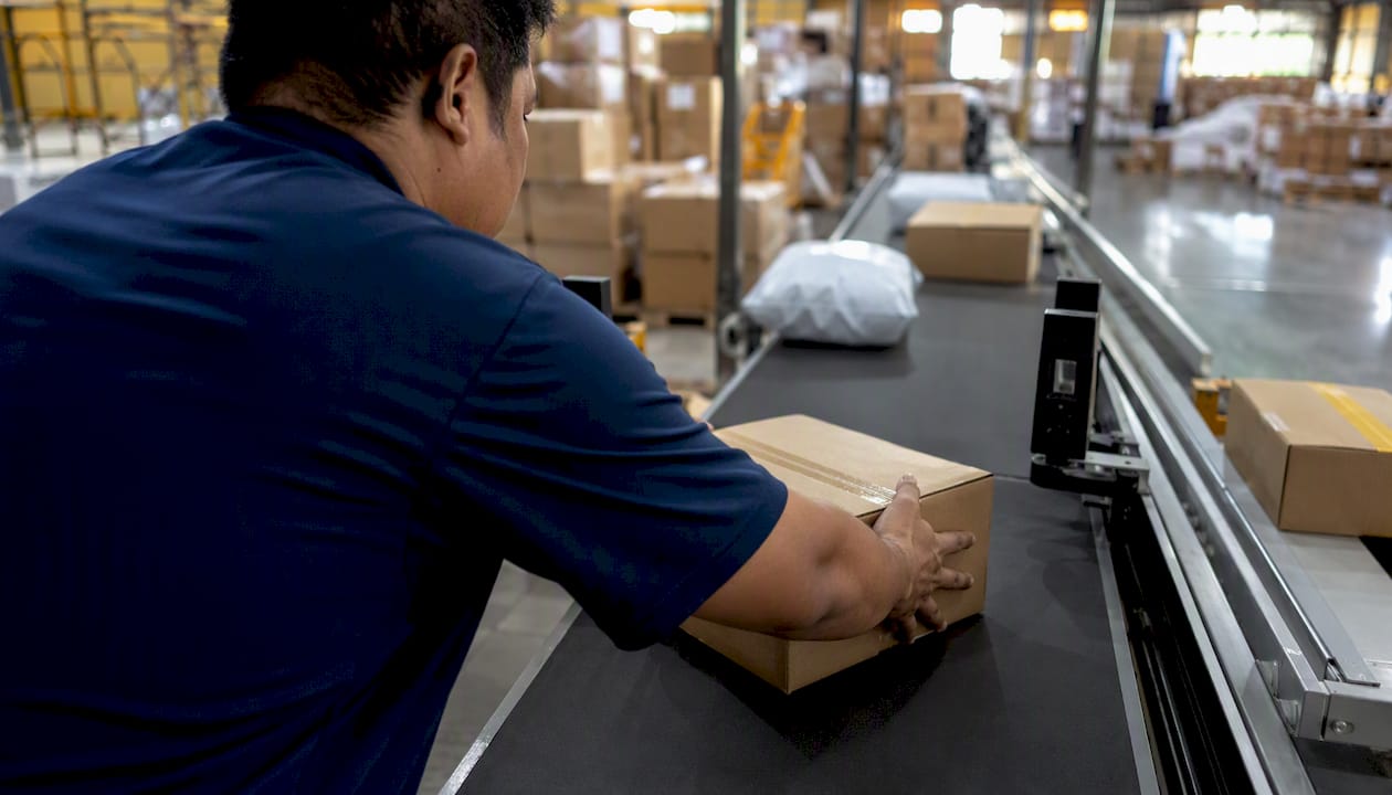 Worker sorting packages at regional shipping hub