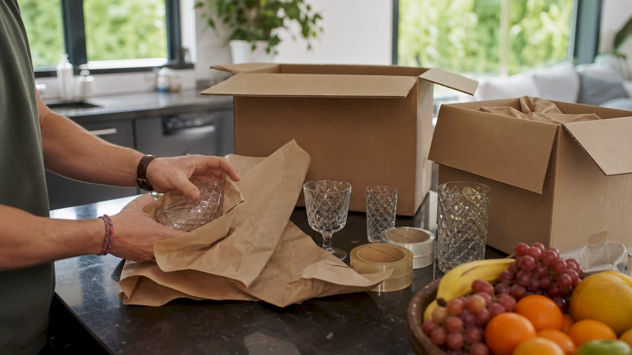 Hands packing fragile items carefully