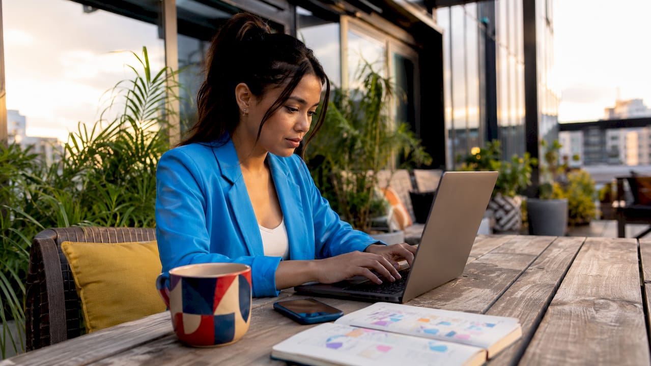 Woman managing multiple social media platforms on laptop.