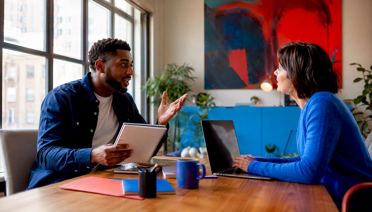 Two people discussing influencer reach in café