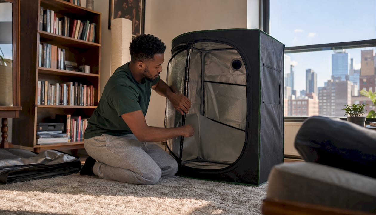 Man inspecting compact grow tent indoors