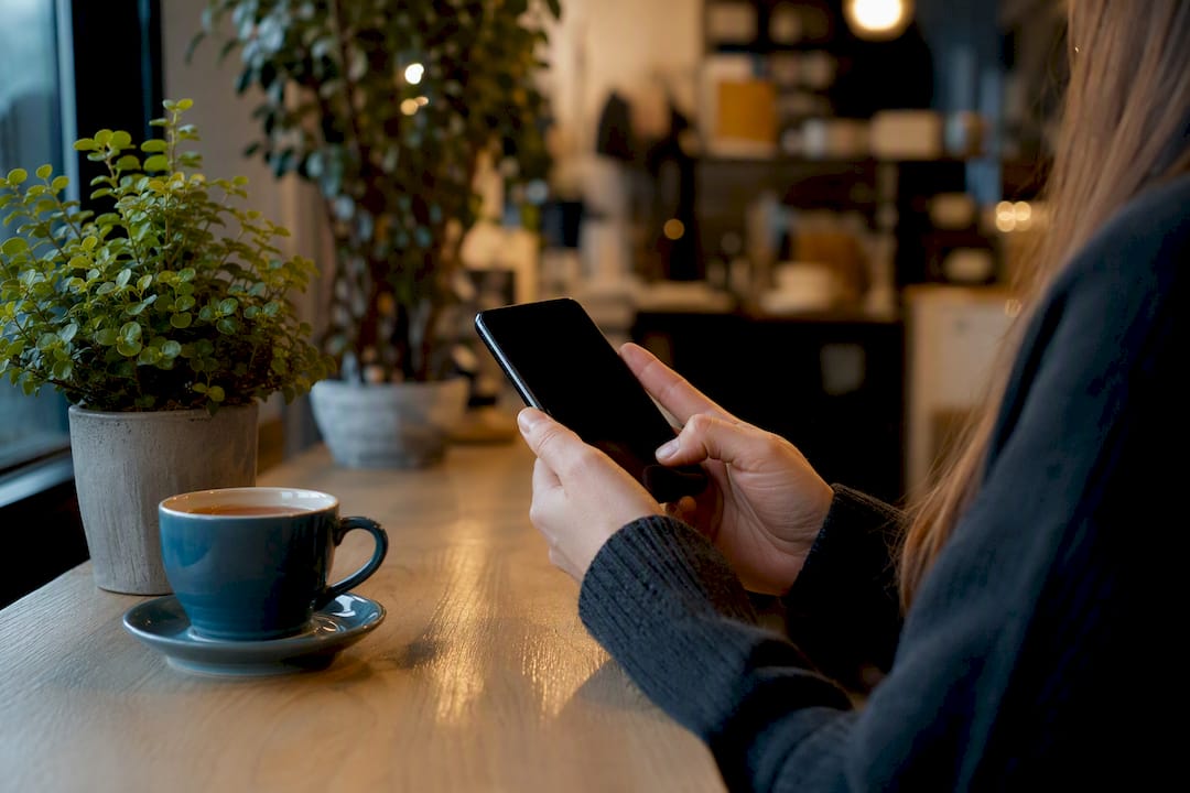 Hand replying to comment on smartphone in local shop