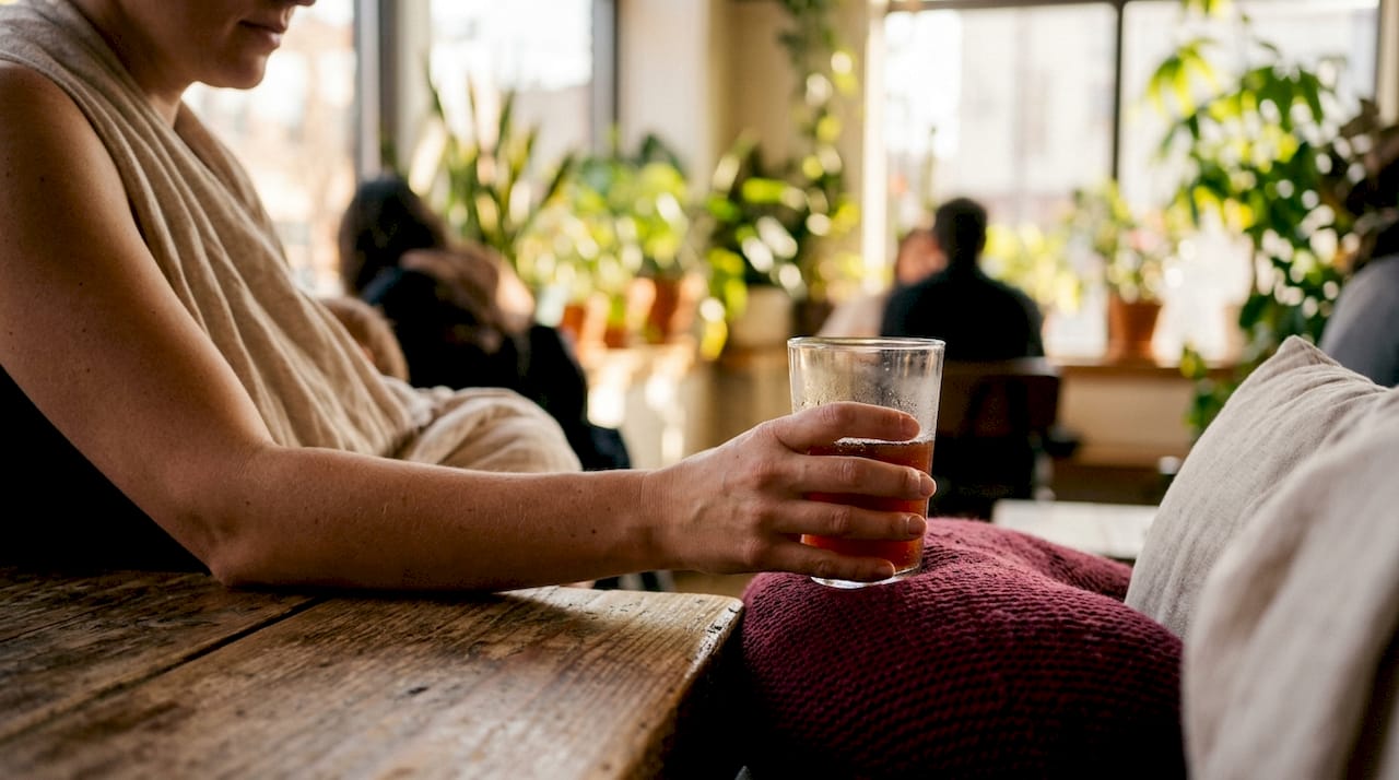 Breastfeeding mother placing kombucha glass