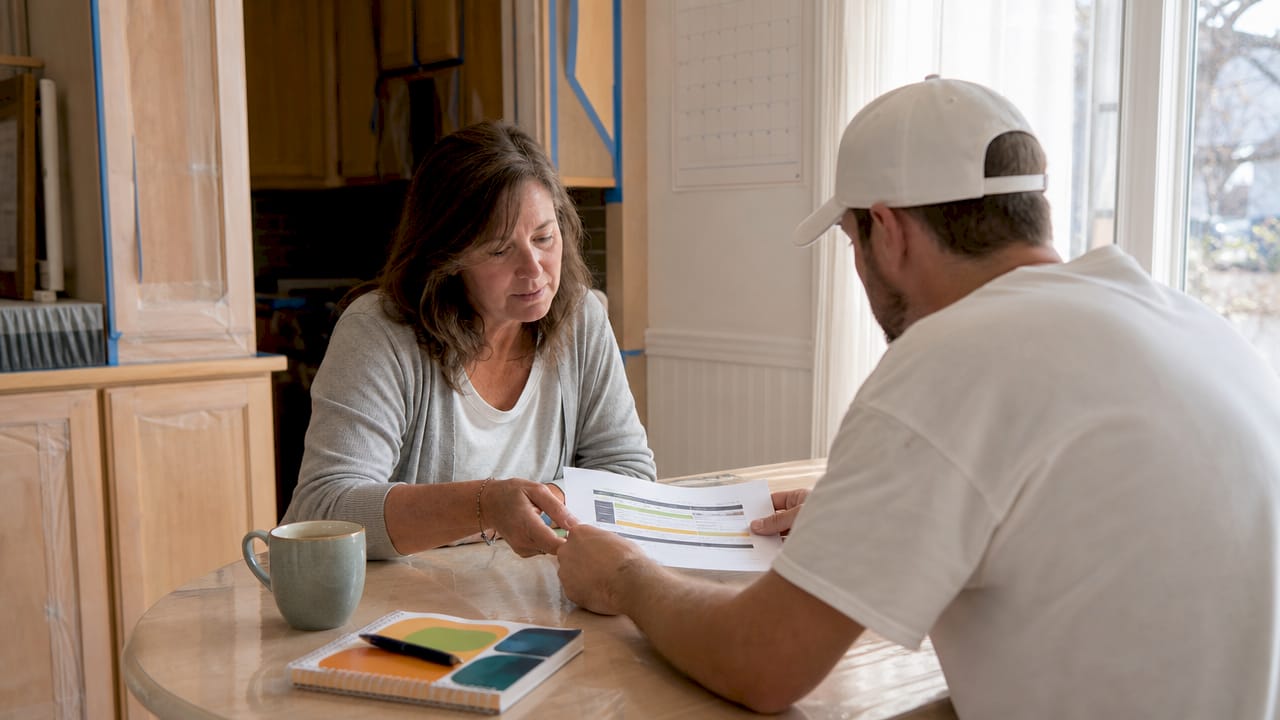 Homeowner reviewing kitchen painting schedule with painter
