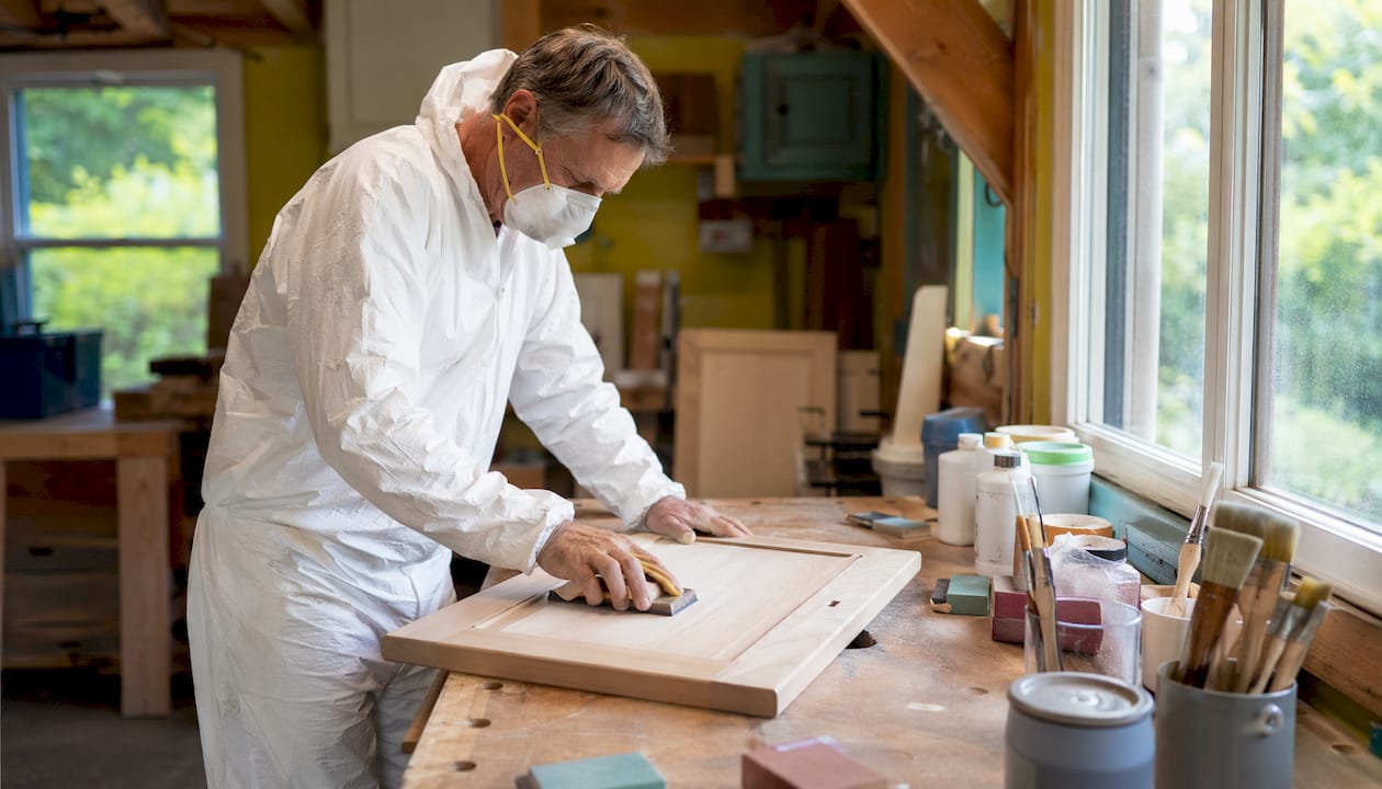 Man sanding kitchen cabinet in Ottawa home