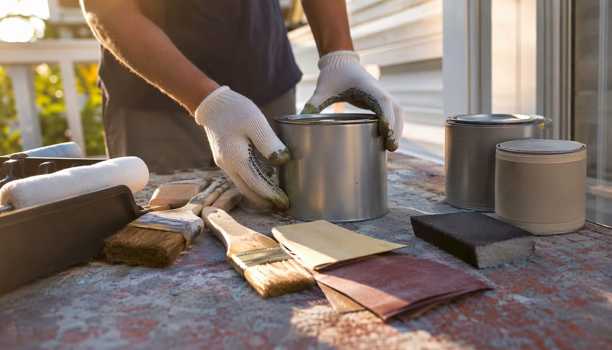 Hands assembling cabinet refinishing tools on table