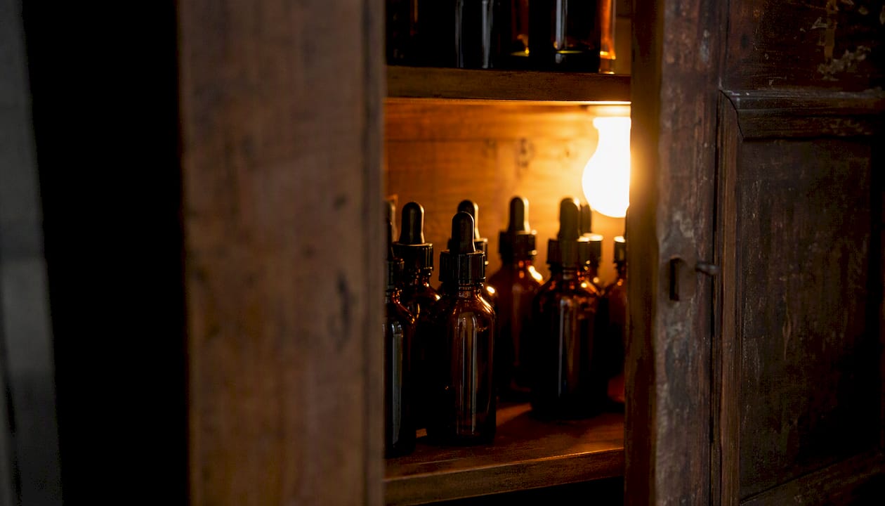 Amber glass tincture bottles neatly stored in cabinet
