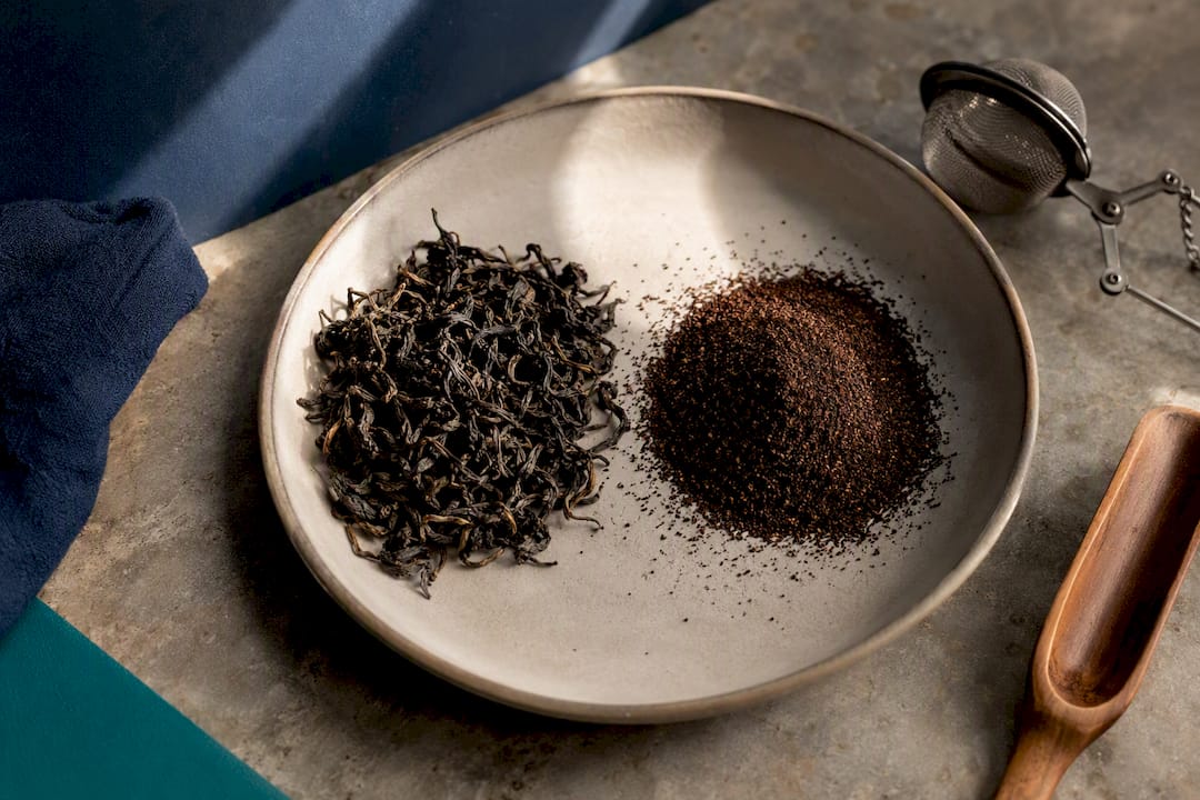 Intact tea leaves beside fine tea particles