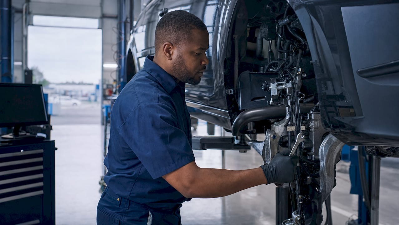 Mechanic inspecting car engine in repair shop