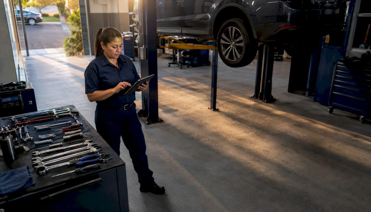 Mechanic managing reputation with tablet in garage