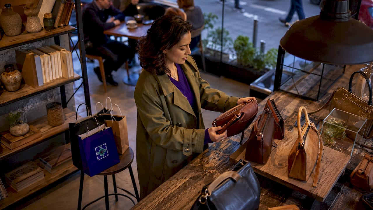 What Is Accessible Luxury? Your Annual Guide Woman shopping for luxury handbags in boutique