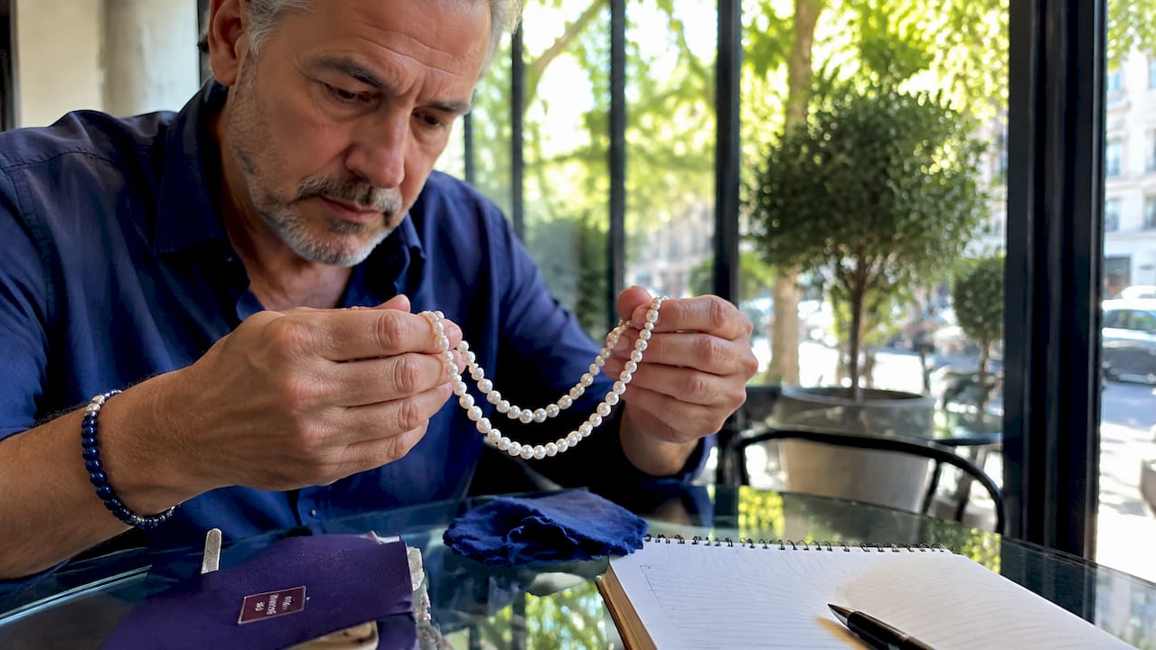 Why Pearl Jewelry Is Undervalued: What Buyers Miss Hands comparing pearls over wooden table