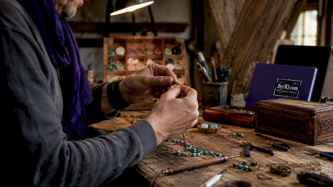 What Is Wearable Art Jewelry? A Guide to Artistic Style Close-up of hands making artisan jewelry with pearls