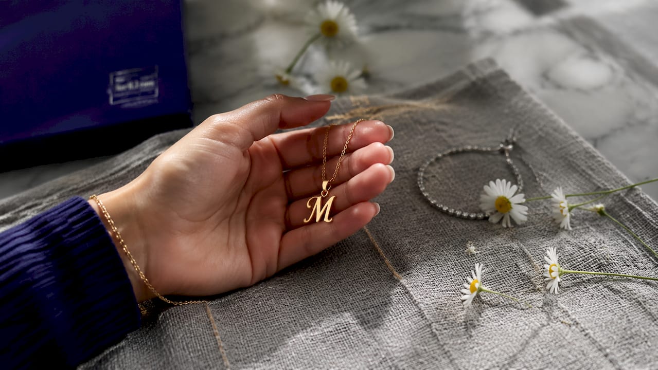 Meaningful Jewelry Gifts for Her: Top 8 Ideas Close-up of hand holding personalized name necklace