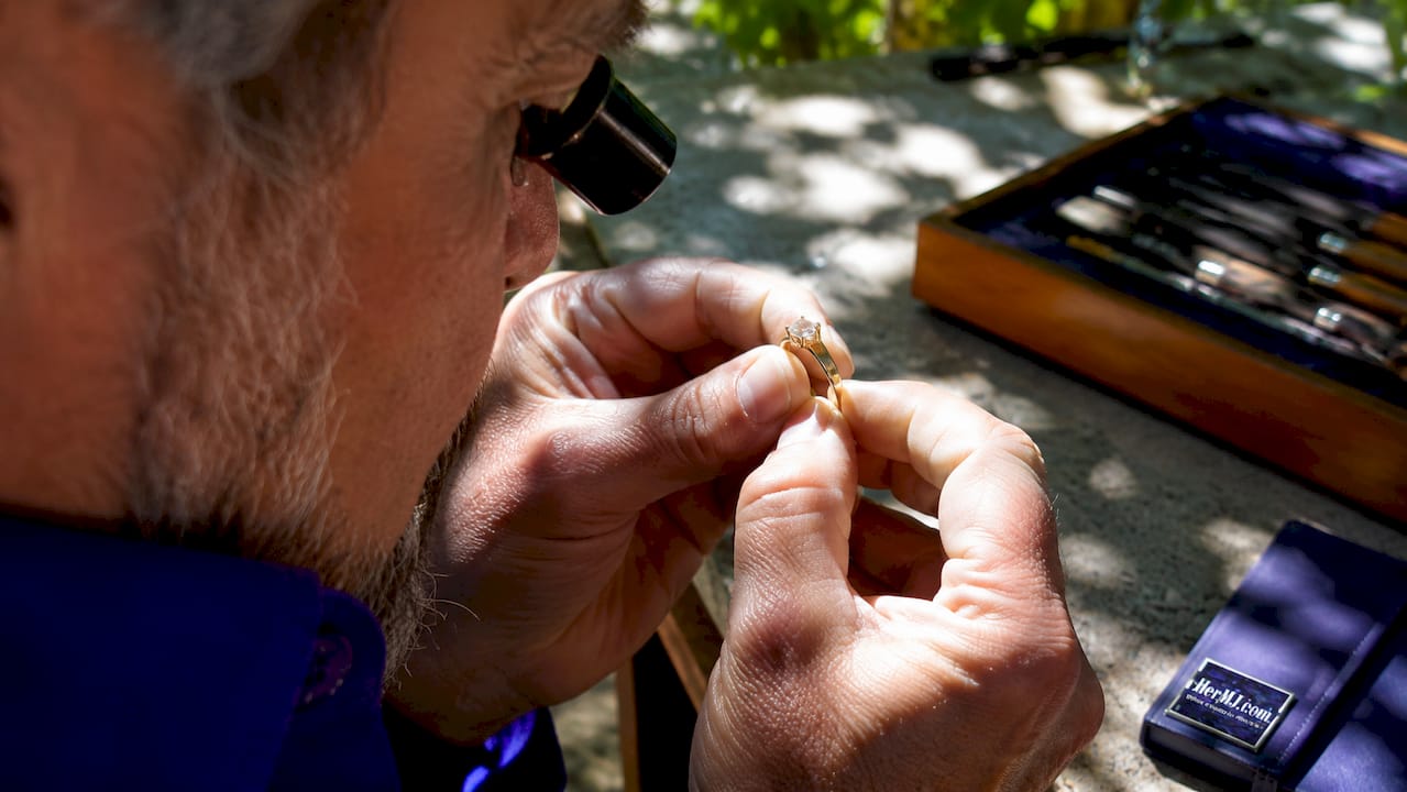 How to Evaluate Gemstone Setting Handmade Quality Close-up hands examining gemstone prong setting