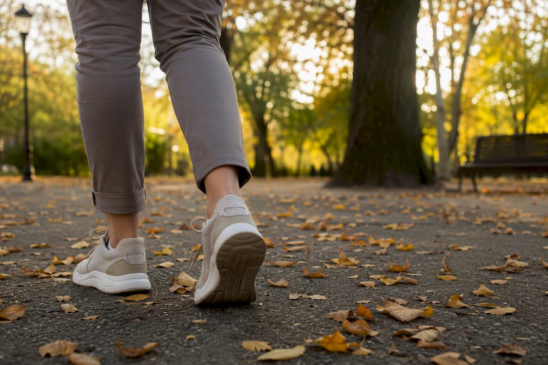 Close-up of legs walking outdoors on park path