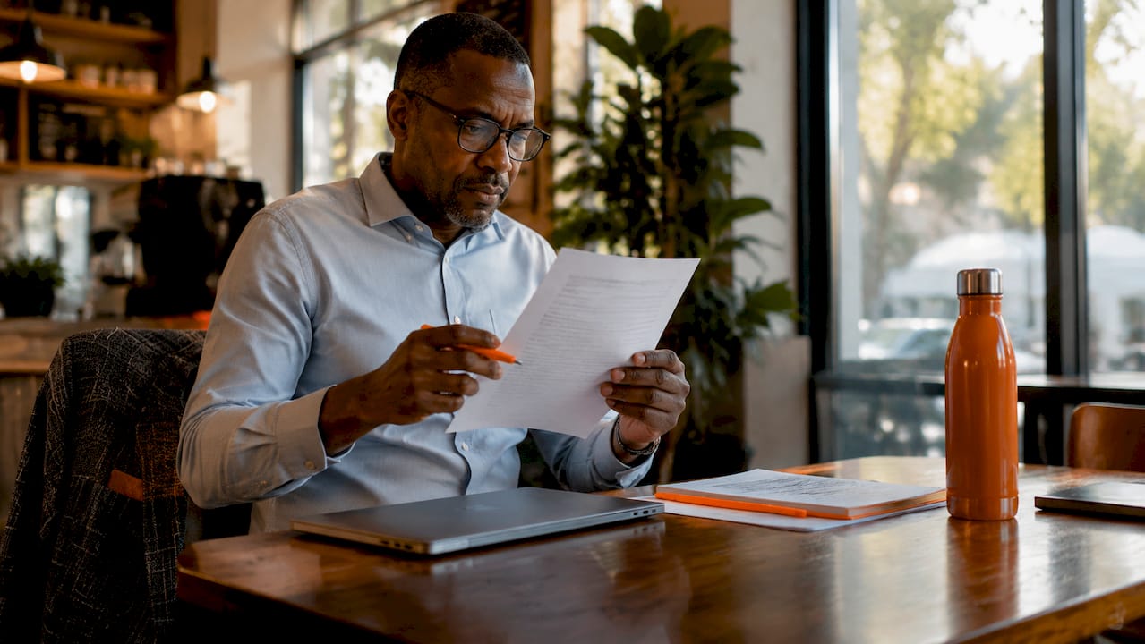 Man reviewing printed cover letter in office