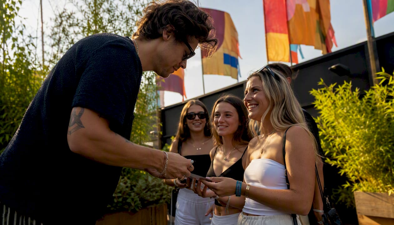 Artist handing signed item to fan backstage