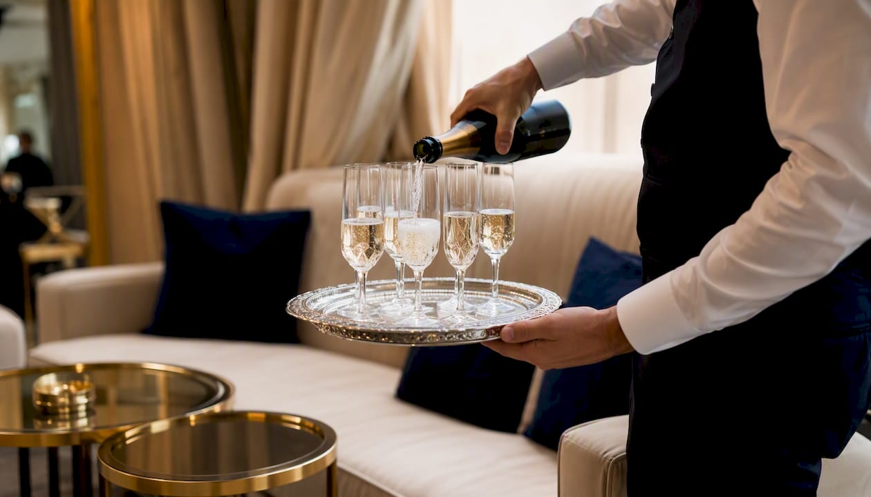 Server pouring champagne at VIP backstage lounge