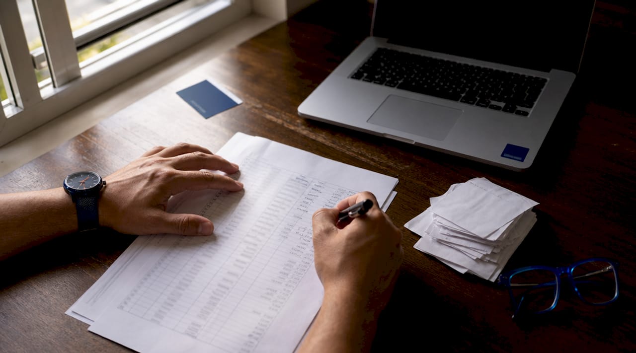 Hands calculating solo 401(k) contributions