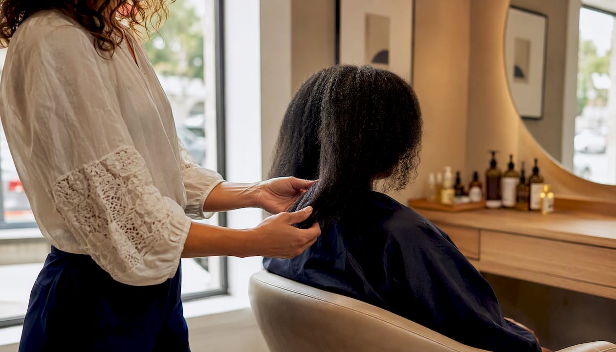 Stylist applying oil to coarse hair ends