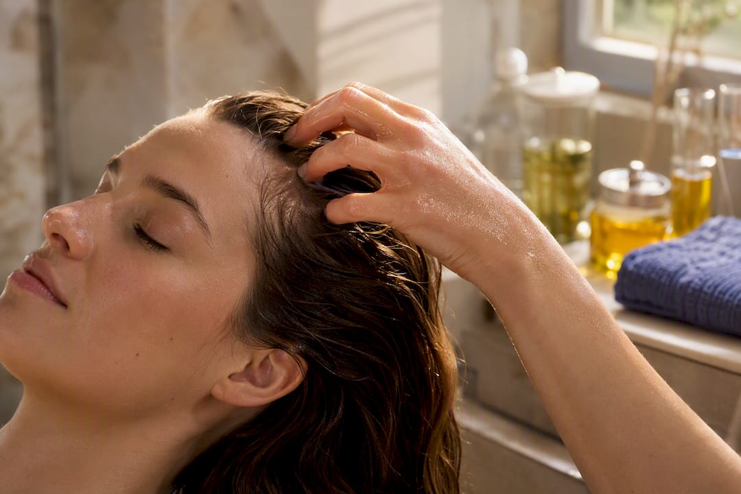 Applying botanical oil to scalp hair