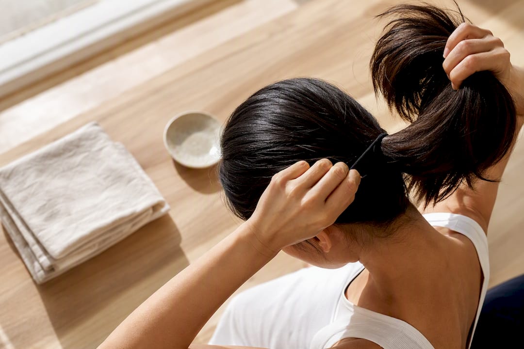 Woman loosening a tight ponytail