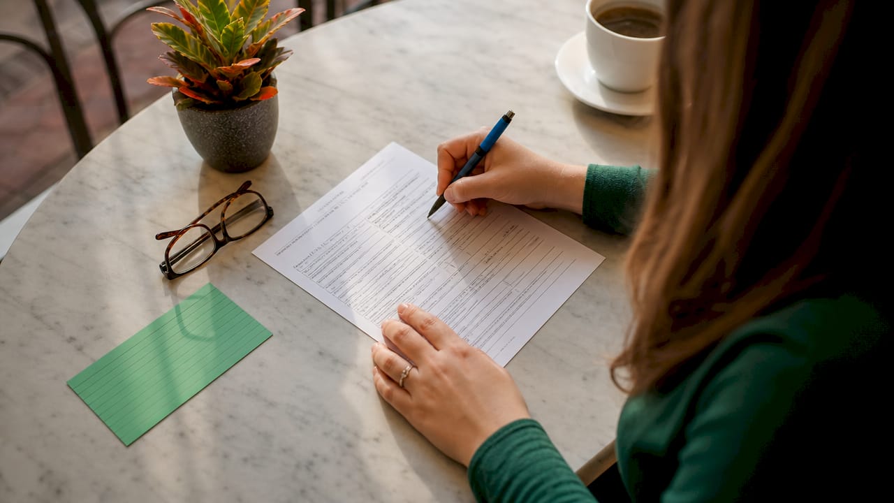 Hands completing fictitious name registration form