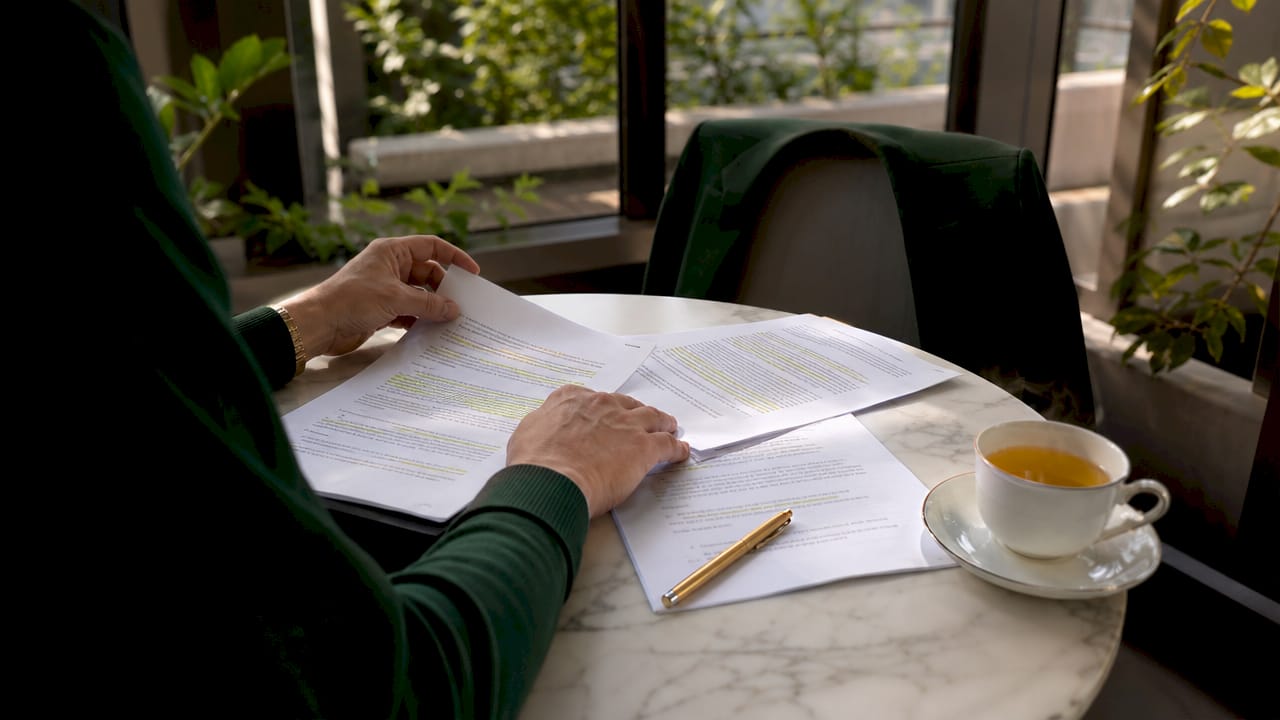 Close-up hands reviewing contract clauses on desk
