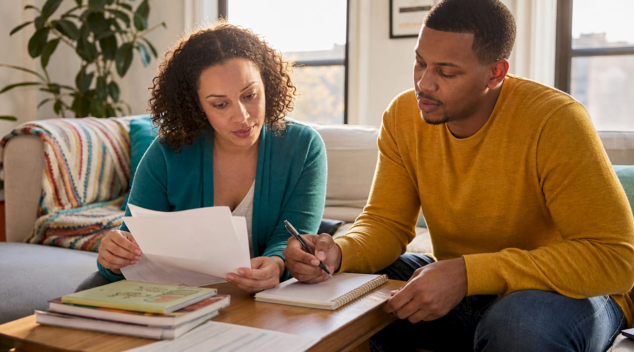 Parents reviewing school reports and notes for ADHD evaluation