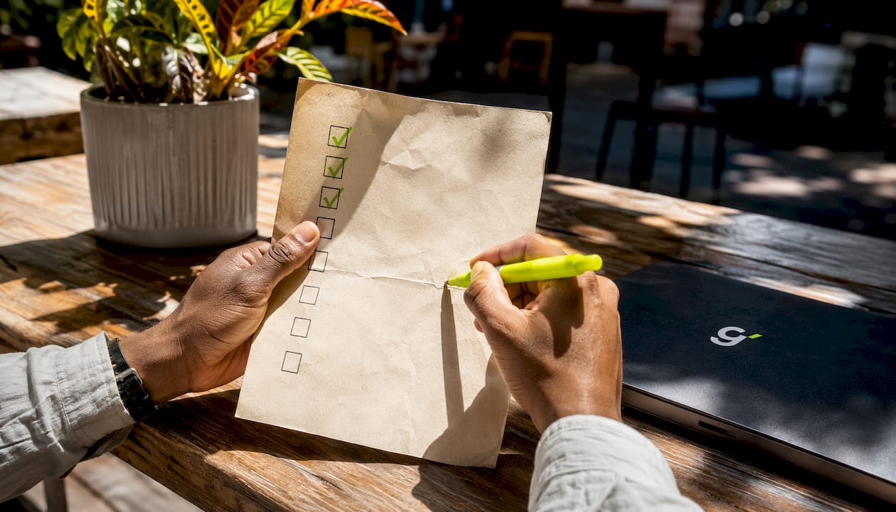 Hands marking eco-cleaning checklist in office