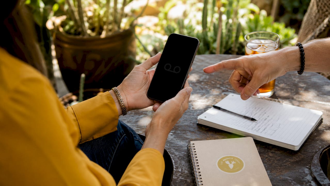 Hands checking voicemail on smartphone in home