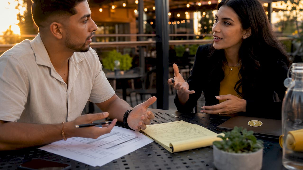 Hands reviewing Arizona closing cost papers in café
