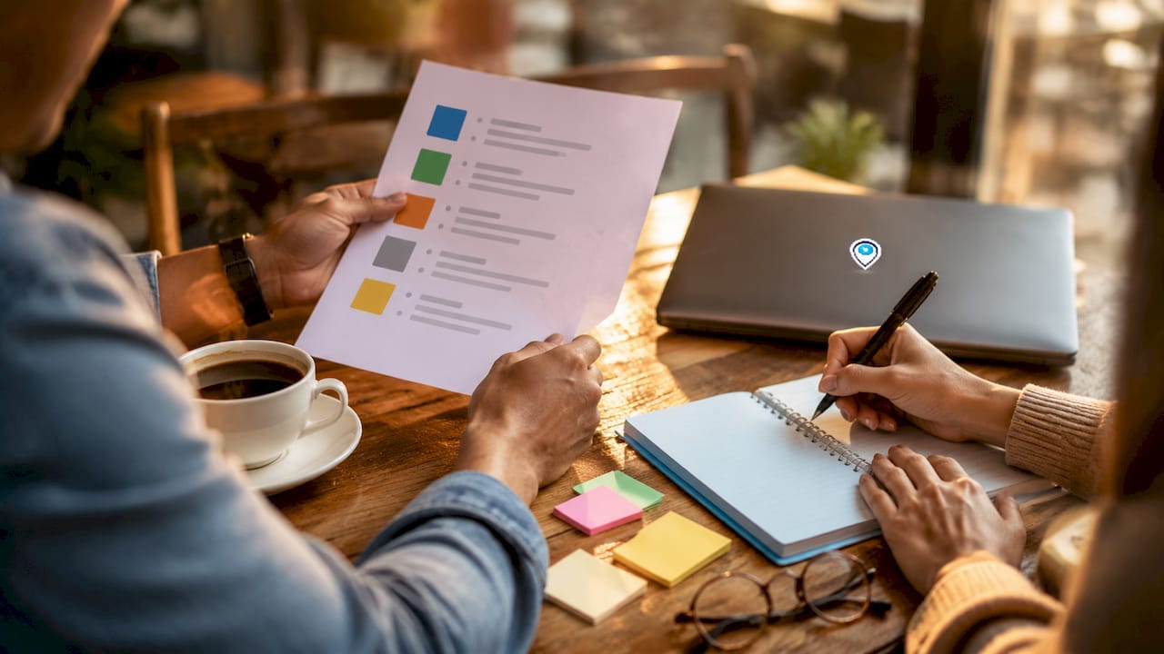 Hands reviewing job posting platforms on tablet and paper