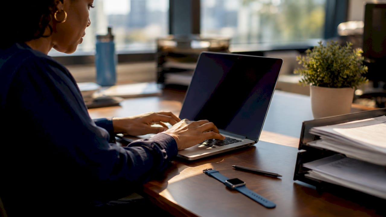 Dispatcher typing on laptop coordinating plumbing jobs