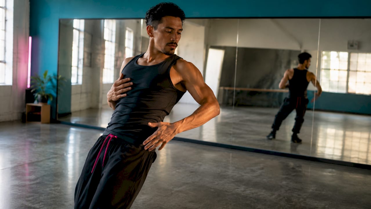 Male dancer practicing chest isolations in home studio