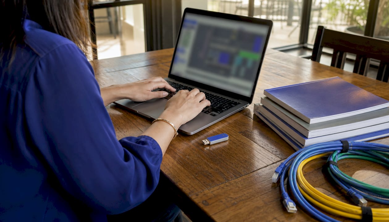 Hands preparing PLC programming software on laptop