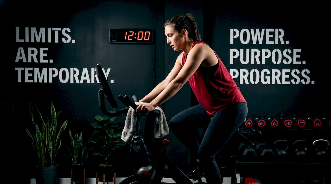 Woman cycling slowly for recovery at gym