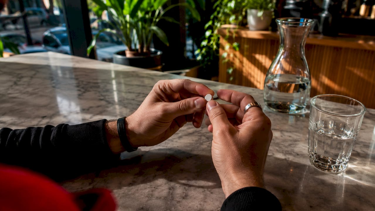 Unas manos sostienen pastillas de bupropión.