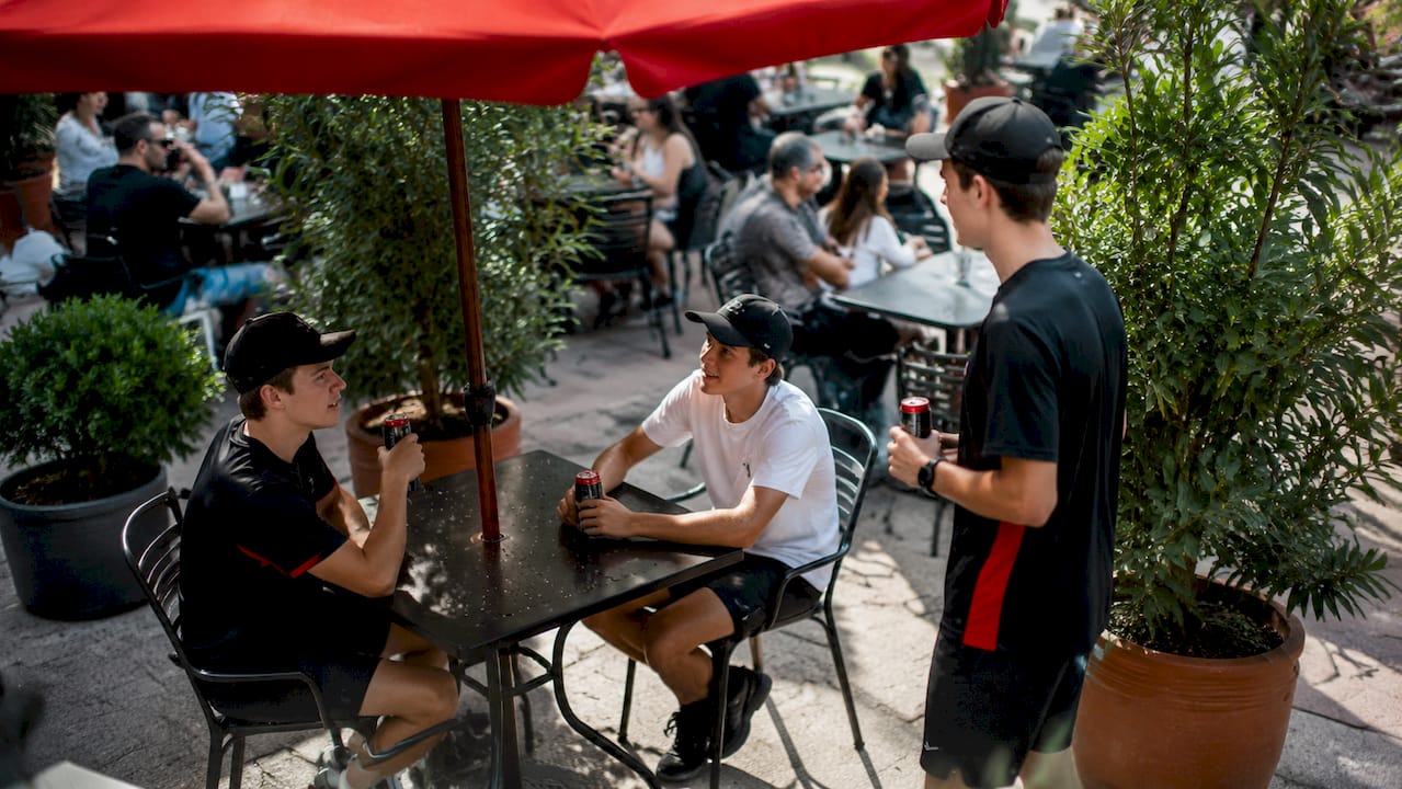 Un grupo de adolescentes tomando bebidas energéticas en el parque