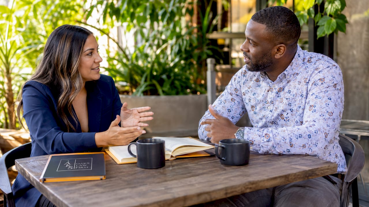 Two attorneys discussing referral over coffee