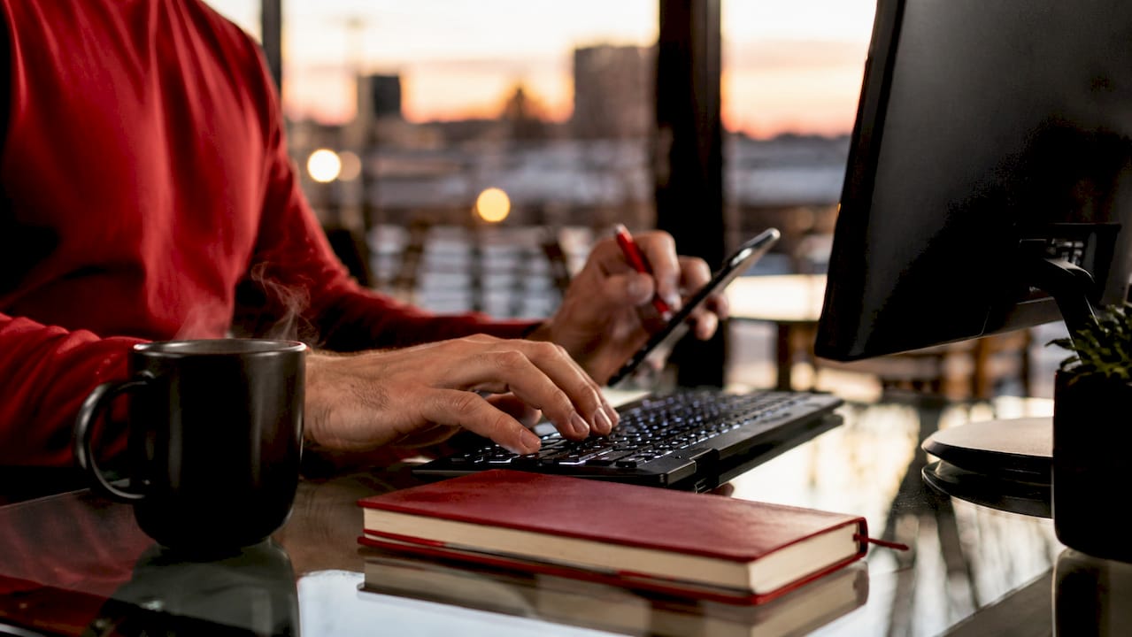 Close-up of hands using devices in home office